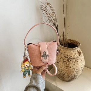 Rosa gewebte Mini-Handtasche für Mädchen mit niedlichem Puppenanhänger und Drehverschluss