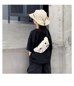 Detail of a minimalist beige kids functional chest bag with drawstring design in street style
