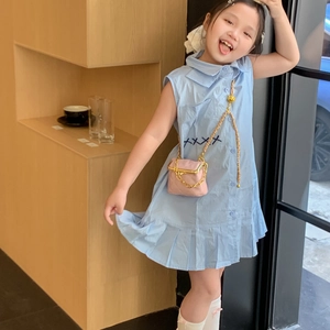Girl's light blue sleeveless pleated dress paired with a pink quilted chain mini bag