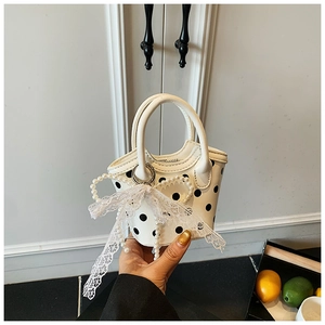 Détail du mini sac à pois avec décoration de nœud en perles et bordure en dentelle