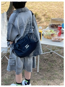 Outdoor leisure black nylon crossbody bag for kids shown in a cozy camping scenario