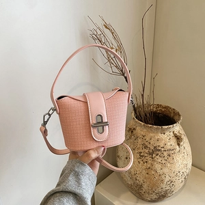 Detailaufnahme der rosa strukturierten Beuteltasche mit silbernem Drehverschluss und Ledergriff