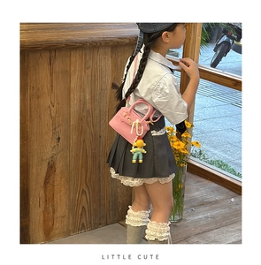 Detailed view of pink shell-shaped mini bag for kids with pearl chain and cute toy charm