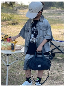 Outdoor camping scene showing a black multifunctional travel bag for kids and teenagers