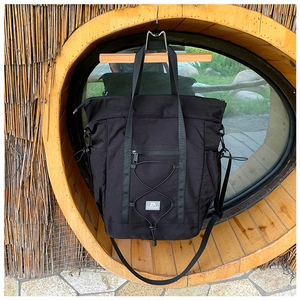Detail of black nylon travel tote with drawstrings and functional zipper pockets