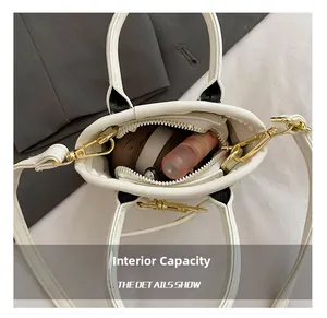 Internal capacity of mini white PU leather shell bag showing space for a lipstick