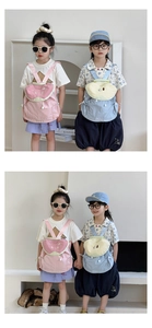 Close-up of children's fruit-themed backpacks in pink watermelon and light blue pear shapes