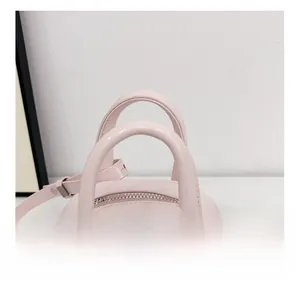 Détail du sac bowling en cuir verni rose avec fermeture éclair et poignées renforcées