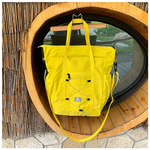 Detail of yellow nylon travel tote featuring drawstring design and durable handles