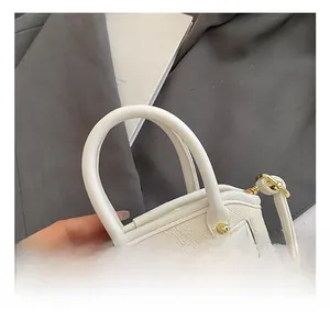 Close-up of comfortable white pebbled leather handles and gold metal hardware