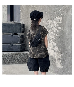 Close-up of kids black nylon chest bag with street style camo t-shirt and cargo shorts