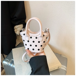 Détail d'un mini sac à main rose à pois avec poignée en perles pour petites filles
