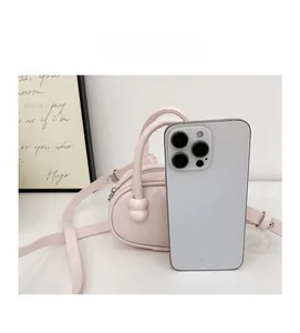 Mini sac polochon rose pour enfants posé près d'un smartphone pour montrer sa taille