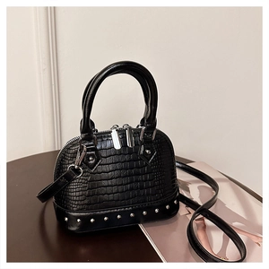 Detail of black crocodile texture handbag featuring silver studs and dual zippers