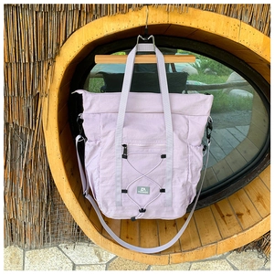 Detail of lavender nylon travel bag with elastic drawstrings and adjustable strap