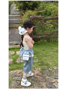Détail d'un sac bandoulière blanc pour fille avec nœud bleu et inscription MILK