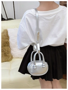 Mini sac bowling argenté métallisé pour enfant porté en bandoulière par un modèle
