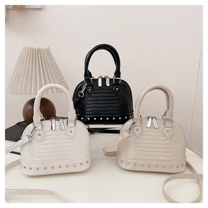 Detail of rivet trim and crocodile pattern on mini shell bags in multiple colors