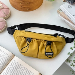 Detail of bright yellow kids chest bag with elastic drawstrings and adjustable strap
