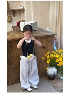 Détail du mini sac bandoulière violet avec nœud jaune pour fille et tenue stylée enfant