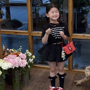 Mode-Set für Mädchen mit schwarzem Tüllrock, roter Handtasche und Puppenanhänger
