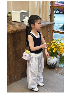 Gros plan d'un mini sac bandoulière violet avec nœud jaune et lettrage Milk pour enfant