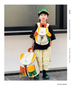 Detail of colorful contrast-color kids backpack and matching cap in outdoor setting