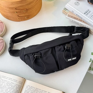 Detail of black nylon kids chest bag featuring front pockets and adjustable buckles