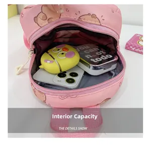 Pink cartoon backpack interior showing storage for phone and accessories