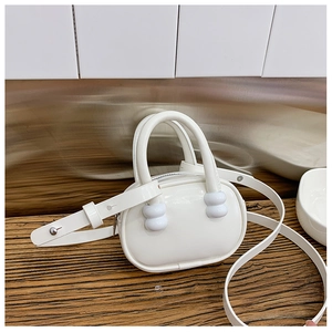 Détail du mini sac bowling blanc brillant avec deux poignées et bandoulière longue