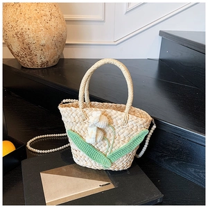 Detail of straw mini bag with 3D floral crochet and elegant pearl chain strap