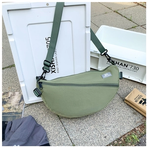 Détail du sac bandoulière en nylon vert avec fermeture éclair et sangle réglable