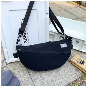 Vue détaillée du sac bandoulière noir en nylon en forme de croissant avec logo et fermeture