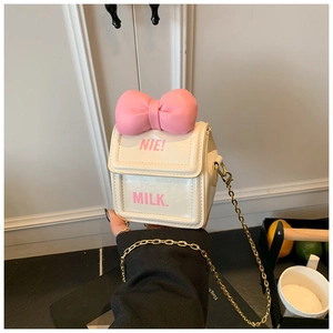 Détail du sac bandoulière blanc en forme de brique de lait avec nœud rose et chaîne
