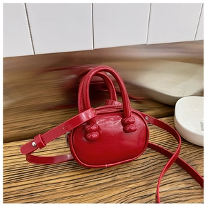 Détail du mini sac bowling rouge brillant pour enfants en cuir verni avec bandoulière longue