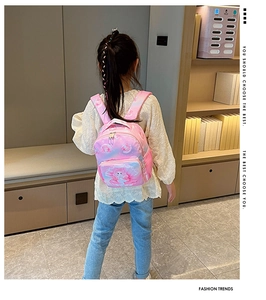 Girl wearing a pink mermaid print backpack in a modern home, showing size and fit