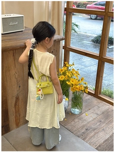 Close-up of neon green leather kids shell bag with lychee texture and cute doll charm