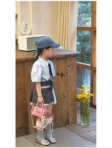Kids vintage style outfit with blue shirt, pleated lace skirt, and pink mini handbag
