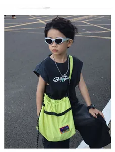 Detail of neon green drawstring kids crossbody bag with colorful scenic embroidery patch