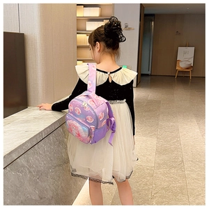 Detail showing the cartoon print, zipper main pocket, and side mesh bag of children backpack
