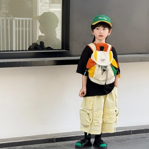 Kids trendy color-block backpack in cream and orange with casual urban style outfit