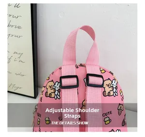 Detailed view of pink cartoon backpack featuring adjustable padded straps and cute prints