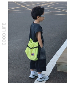 Neon yellow kids drawstring crossbody bag with black straps and sporty patch detail