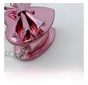 Macro shot of pink heart bag showing precise stitching and pearly bead handle