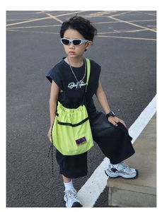 Close-up of a boy wearing a neon yellow crossbody bag with street style sports outfit