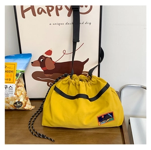 Detail of yellow nylon drawstring crossbody bag with landscape patch and adjustable strap