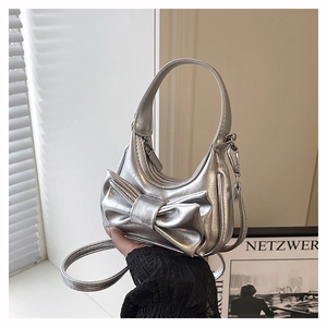 Close-up of silver mini handbag with large bow detail and metallic leather texture