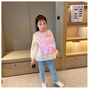 Pink toddler backpack with mermaid print shown on child in a cozy home setting