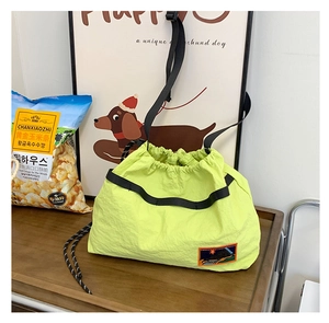 Detail of neon yellow drawstring bag with mountain embroidery and black strap
