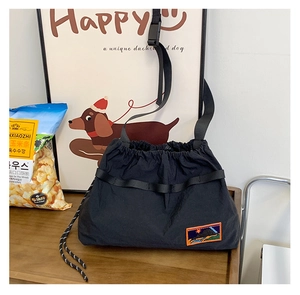 Detail of black drawstring kids bag with colorful embroidery on smooth nylon surface